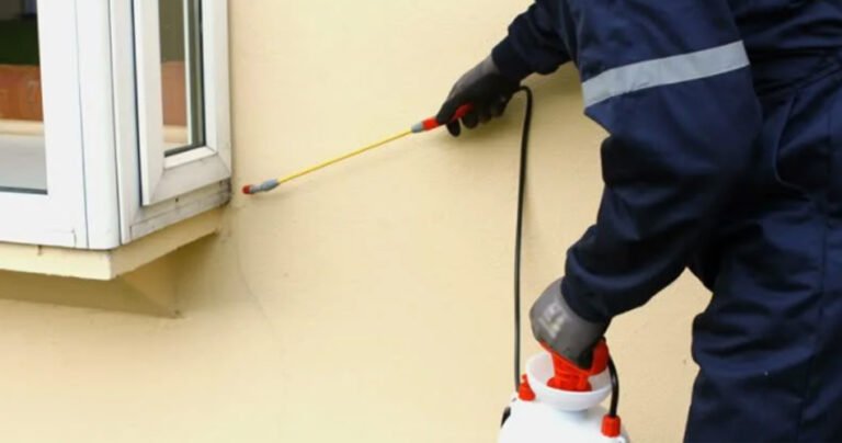 Pest control technician treating a home
